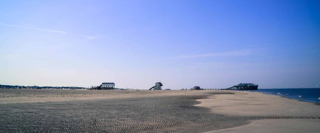 Weite Sicht auf den leeren Nordseestrand bei blauem Himmel