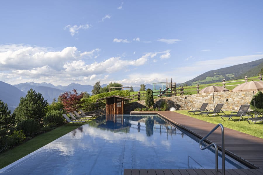 Aussenbereich mit Pool des „Hotel Fischer“ mit Blick auf die Berge und Umgebung