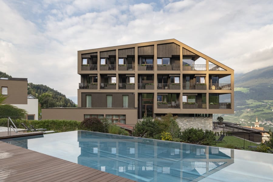Aussenansicht des „Hotel Fischer“ und Pool-Bereichs mit Blick auf die Landschaft